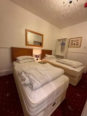 two beds in a hotel room with a mirror at No 34 Vance Road in Blackpool
