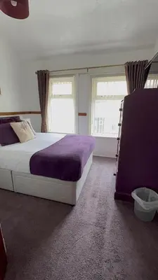 a bedroom with a large bed and two windows at No 34 Vance Road in Blackpool