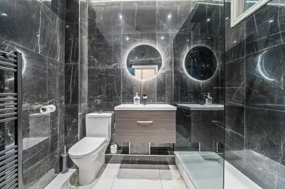 a bathroom with a toilet and a sink and mirrors at Latimer Flat 1 - Spacious 2-Bed Apt - Sleeps 7 - Ground Flr in Liverpool