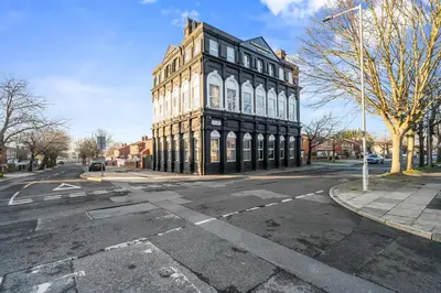 a tall building on the corner of a street at Latimer Flat 1 - Spacious 2-Bed Apt - Sleeps 7 - Ground Flr in Liverpool