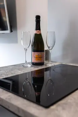 a bottle of wine and two wine glasses on a counter at Prestige Short Stay in Liverpool