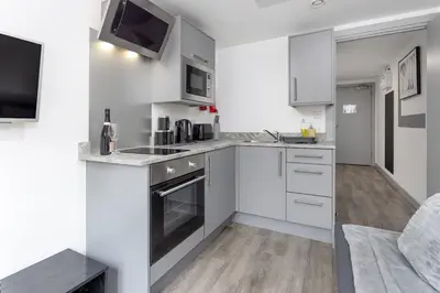 a white kitchen with a sink and a stove at Prestige Short Stay in Liverpool