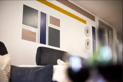 a person sitting on a couch looking at a cell phone at Prestige Short Stay in Liverpool