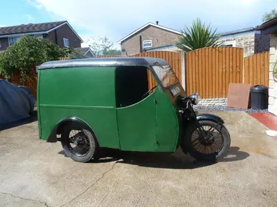 a small green car parked in a driveway at smithy lodge guest house in Leyland