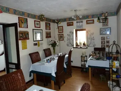 a dining room with two tables and chairs in a restaurant at smithy lodge guest house in Leyland