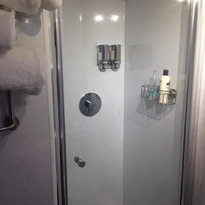 a shower in a bathroom with a glass door at smithy lodge guest house in Leyland