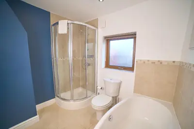 a bathroom with a shower and a toilet and a tub at Modern Cosy 2-Bed Terrace with Private Garden in Eccleston