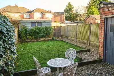 a backyard with a table and chairs and a fence at Modern Cosy 2-Bed Terrace with Private Garden in Eccleston