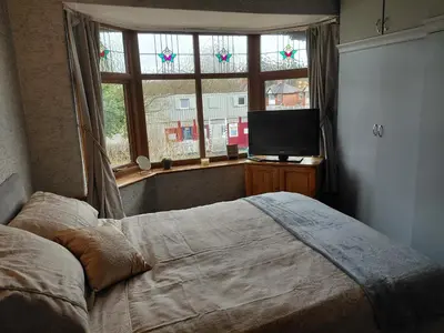 a bedroom with a bed and a flat screen tv at Penwortham traditional home in Penwortham