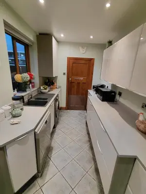 a large kitchen with white counters and a door at Penwortham traditional home in Penwortham