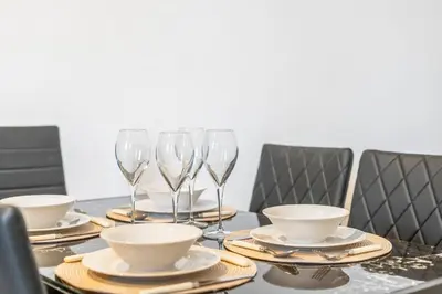 a table with plates and wine glasses on it at Latimer Flat 2 - Spacious 2-Bed Apt - Sleeps 7 in Liverpool