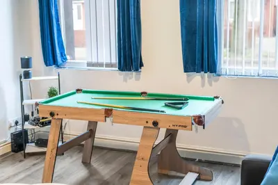 a ping pong table in a room with blue curtains at Latimer Flat 2 - Spacious 2-Bed Apt - Sleeps 7 in Liverpool