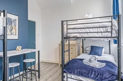 a bedroom with a bunk bed with blue walls at Latimer Flat 2 - Spacious 2-Bed Apt - Sleeps 7 in Liverpool