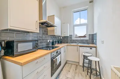 a kitchen with a microwave and a sink and a stove at Latimer Flat 2 - Spacious 2-Bed Apt - Sleeps 7 in Liverpool