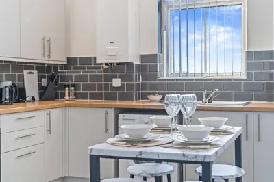 a kitchen with a table with wine glasses on it at Latimer Flat 3 - Spacious 2-Bed Apt - Sleeps 6 in Liverpool