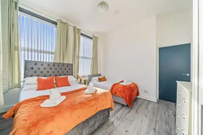 a bedroom with two beds with orange pillows at Latimer Flat 4 - Spacious 2-Bed Apt - Sleeps 6 in Liverpool