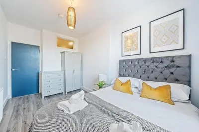 a bedroom with a large white bed with yellow pillows at Latimer Flat 5 - Spacious 2-Bed Apt - Sleeps 7 in Liverpool