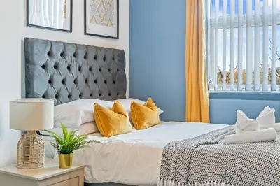 a bedroom with a bed with yellow pillows at Latimer Flat 5 - Spacious 2-Bed Apt - Sleeps 7 in Liverpool