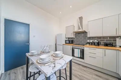 a kitchen with a table with dishes on it at Latimer Flat 6 - Spacious 2-Bed Apt - Sleeps 7 in Liverpool