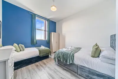 two beds in a room with blue walls at Latimer Flat 6 - Spacious 2-Bed Apt - Sleeps 7 in Liverpool