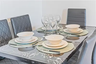 a dining table with dishes and wine glasses on it at Latimer Flat 6 - Spacious 2-Bed Apt - Sleeps 7 in Liverpool
