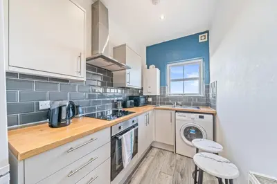 a kitchen with white cabinets and a washer and dryer at Latimer Flat 6 - Spacious 2-Bed Apt - Sleeps 7 in Liverpool