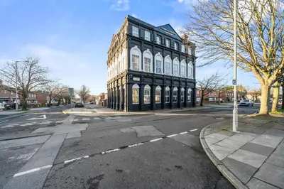 a black and white building on the corner of a street at Latimer Flat 6 - Spacious 2-Bed Apt - Sleeps 7 in Liverpool
