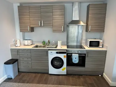 a kitchen with a washing machine and a sink at Melbourne House Apartment Near Train Station! in Accrington