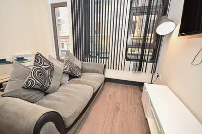 a living room with a couch and a large window at Modern & Cosy 2BED Apartment in Central Liverpool in Liverpool