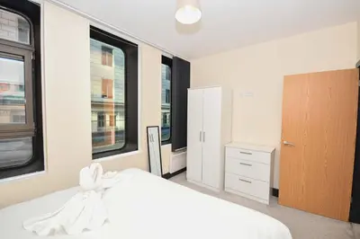 a bedroom with a white bed and two windows at Modern & Cosy 2BED Apartment in Central Liverpool in Liverpool