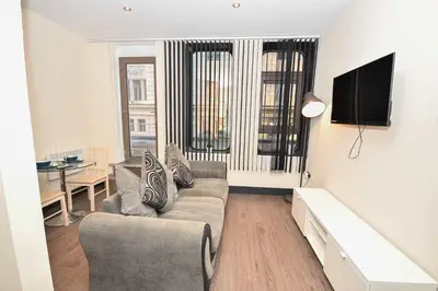 a living room with a couch and a table at Modern & Cosy 2BED Apartment in Central Liverpool in Liverpool