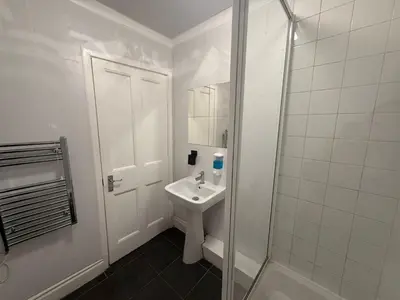a white bathroom with a sink and a shower at Blackpool - Apartment - Sleeps 6- Coastal Stay in Blackpool
