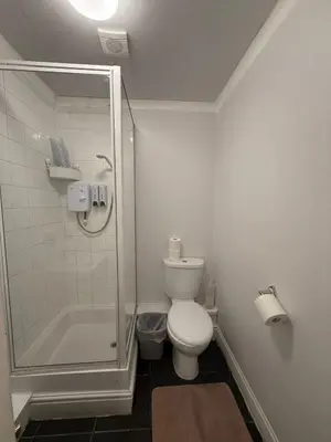 a white bathroom with a shower and a toilet at Blackpool - Apartment - Sleeps 6- Coastal Stay in Blackpool