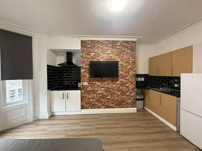 a kitchen with a brick wall with a tv on it at Blackpool - Apartment - Sleeps 6- Coastal Stay in Blackpool