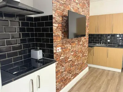 a kitchen with black tiles on the wall at Blackpool - Apartment - Sleeps 6- Coastal Stay in Blackpool