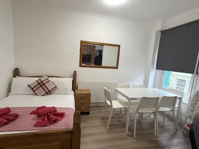 a bedroom with a bed and a table with chairs at Blackpool - Apartment - Sleeps 6- Coastal Stay in Blackpool