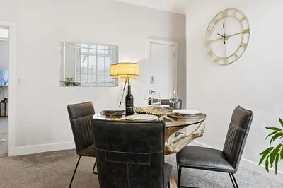 a dining room with a table with chairs and a clock at Stunning 3B Home, ideal for leisure & contractors in Clitheroe