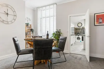a dining room with a table and chairs and a clock at Stunning 3B Home, ideal for leisure & contractors in Clitheroe