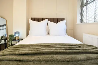 a bedroom with a large bed with white pillows at Calgary Residence in Mellor