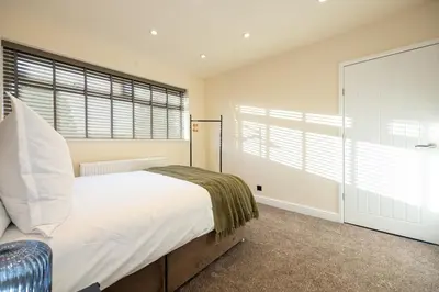 a bedroom with a bed and a large window at Calgary Residence in Mellor
