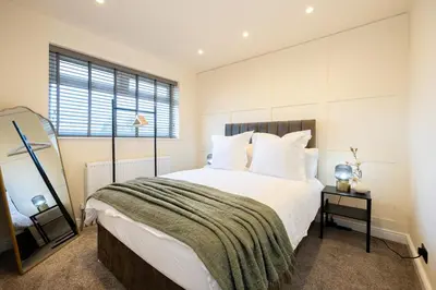 a bedroom with a large bed and a window at Calgary Residence in Mellor