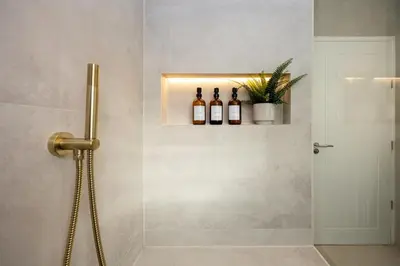 a shower with three bottles of wine on a wall at Calgary Residence in Mellor
