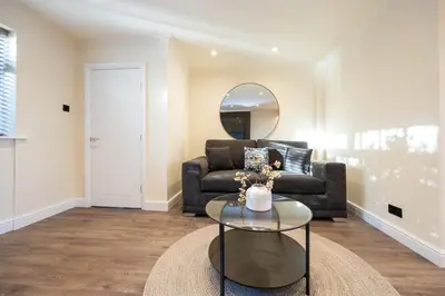a living room with a couch and a glass table at Calgary Residence in Mellor