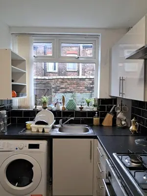 a kitchen with a sink and a washing machine at 16 Skipton Road in Liverpool