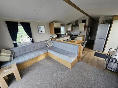a living room with a couch and a kitchen at Rendezvous at Ocean Edge in Heysham