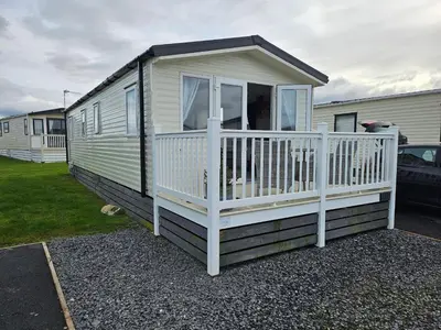 a mobile home with a porch and a white railing at Rendezvous at Ocean Edge in Heysham