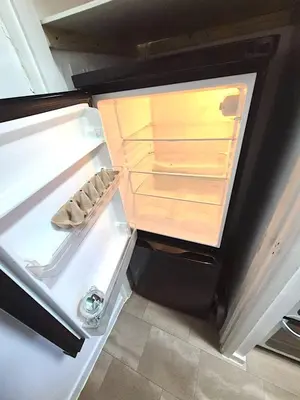 an empty refrigerator with its door open in a kitchen at COZY Apartment 4 in Liverpool