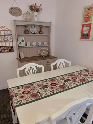 a dining room table with two chairs and a floral table cloth at COZY Apartment 4 in Liverpool