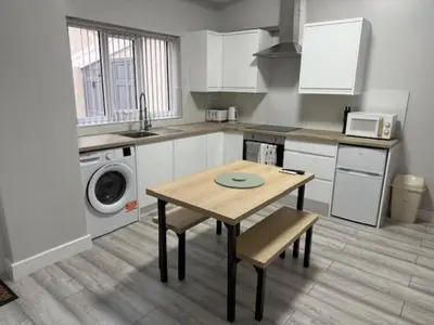 a kitchen with a table and a washing machine at Adrian House Blackpool in Blackpool