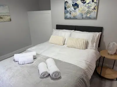 a large white bed with two towels on it at Adrian House Blackpool in Blackpool